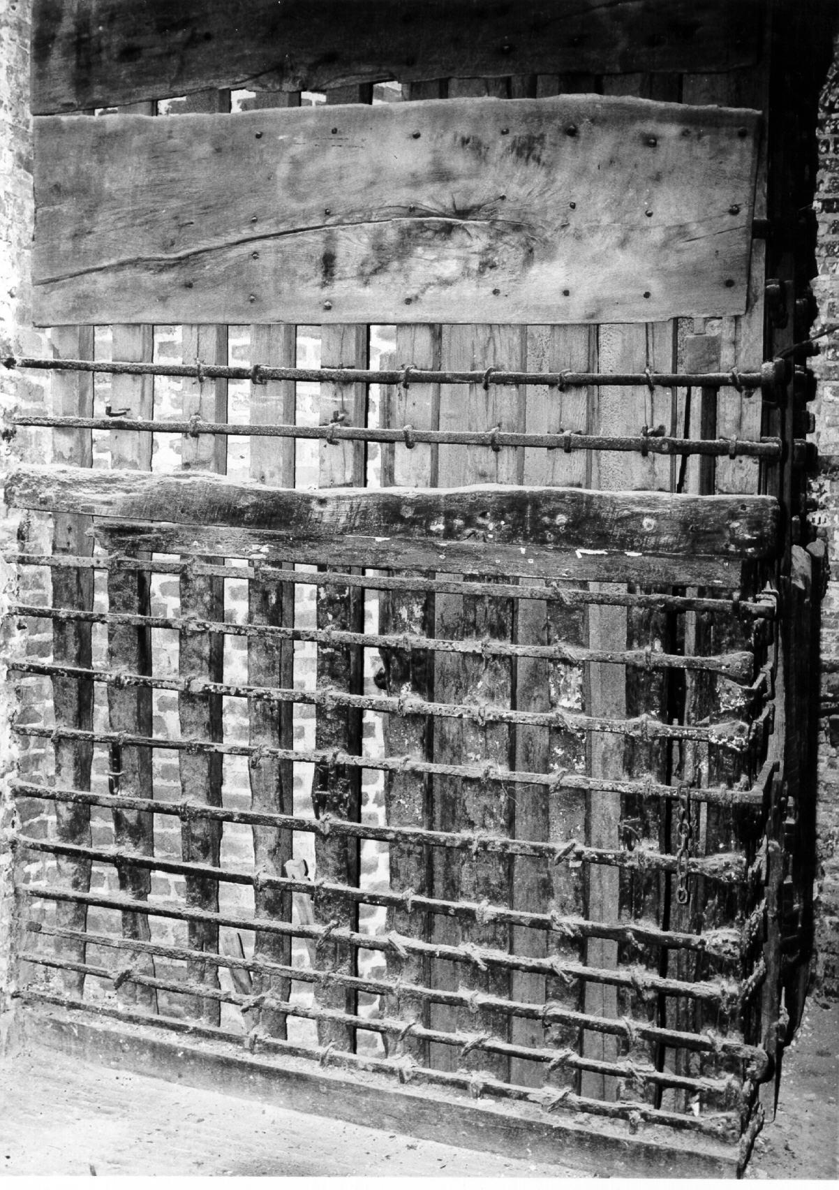 Met tralies beslagen houten wand in een cel in het stadhuis, 1968. GAG.HTA.