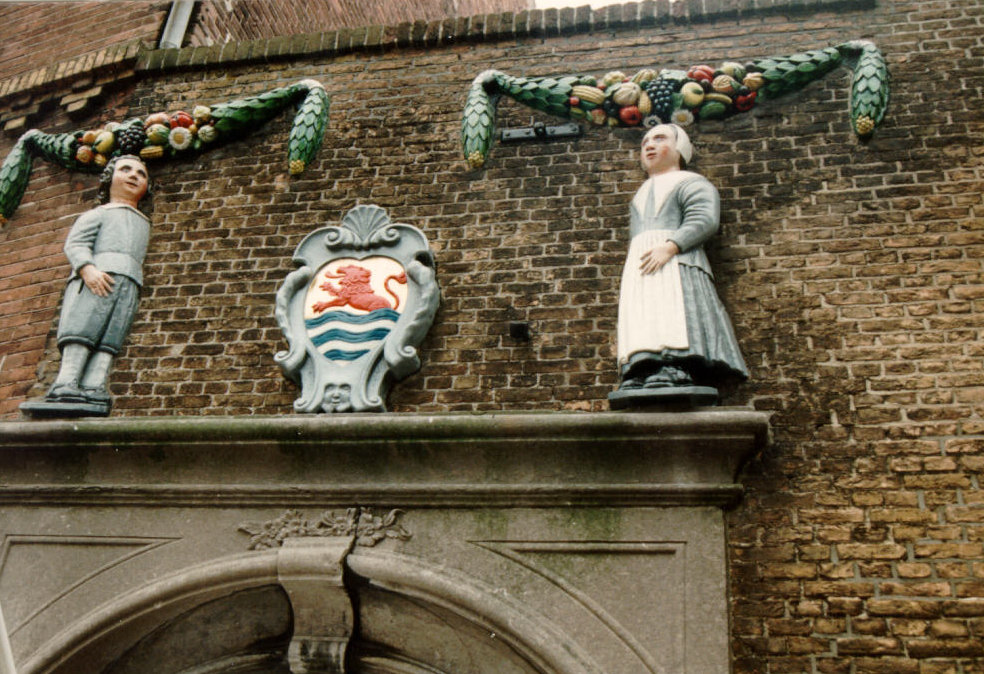 Beschilderde beeldjes boven de poort van het vroegere weeshuis, 1989.